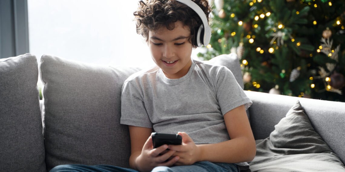 Niño usando un celular (FreePick).