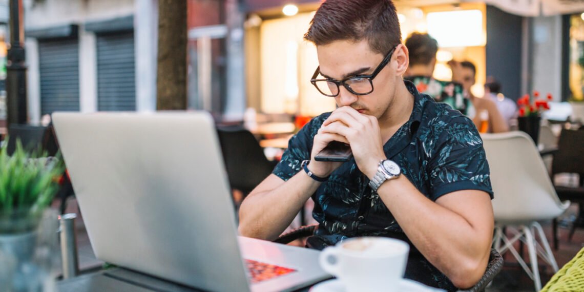 Joven trabajando desde una cafetería (FreePick).