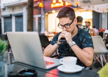 Joven trabajando desde una cafetería (FreePick).