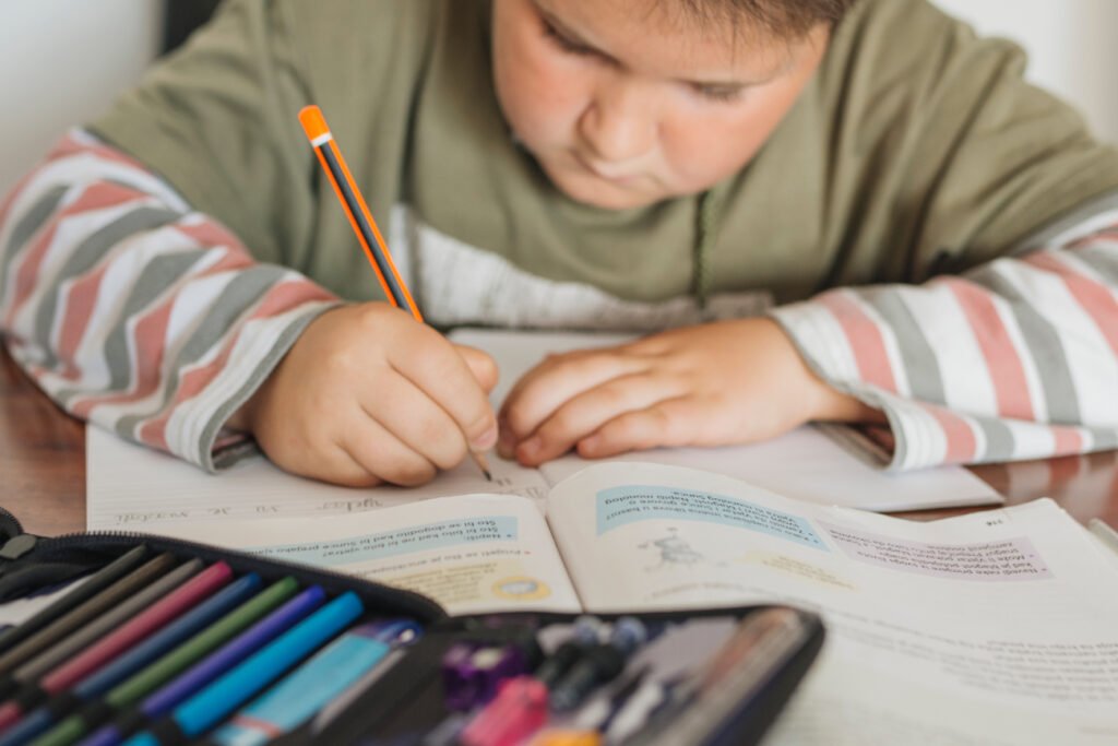 Niño utilizando un cuaderno. Aula. Educación. Escuela (FreePick).