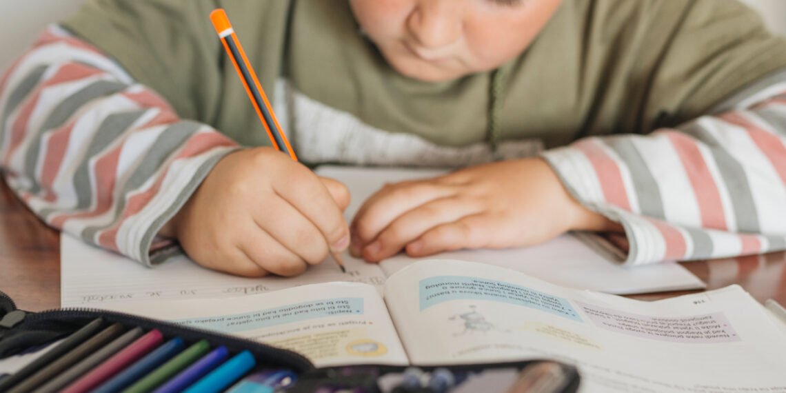 Niño utilizando un cuaderno. Aula. Educación. Escuela (FreePick).