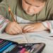 Niño utilizando un cuaderno. Aula. Educación. Escuela (FreePick).