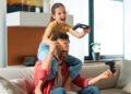 Padre e hija jugando videojuegos (FreePick).