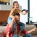 Padre e hija jugando videojuegos (FreePick).
