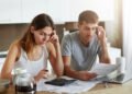 Presupuesto familiar. Pareja revisando gastos y cuentas a pagar (wayhomestudio/FreePick).