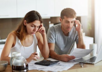 Presupuesto familiar. Pareja revisando gastos y cuentas a pagar (wayhomestudio/FreePick).