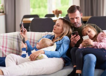 Familia usando el celular (GPointStudio/Magnific).