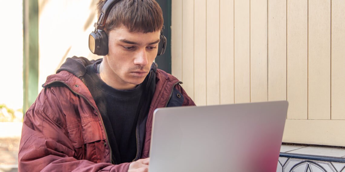 Joven estudiando con una computadora (Magnific/PVProductions).
