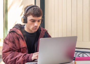 Joven estudiando con una computadora (Magnific/PVProductions).