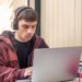Joven estudiando con una computadora (Magnific/PVProductions).