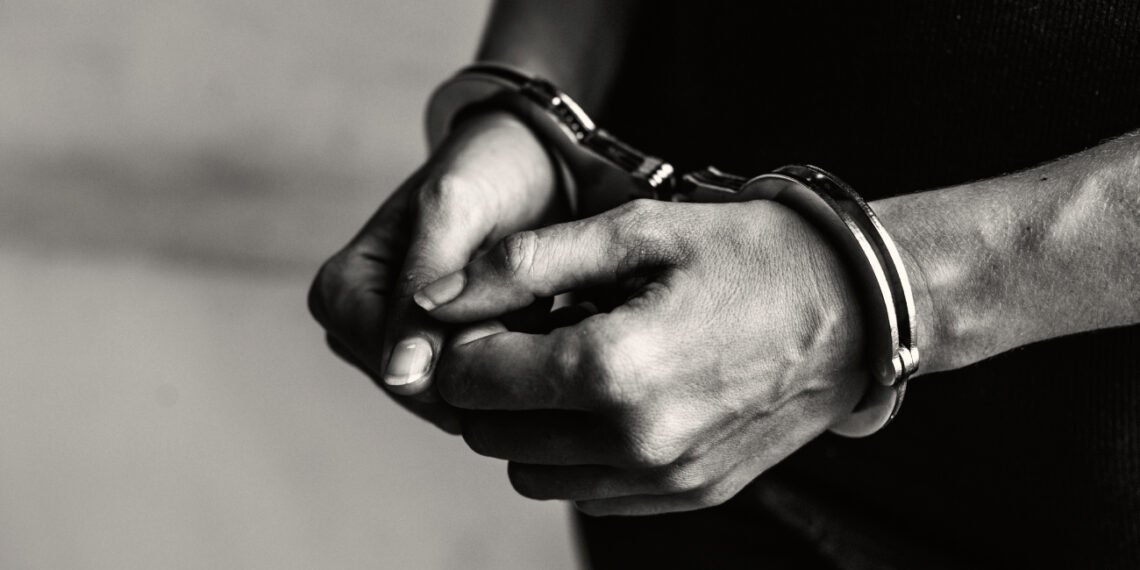 Joven detenido con esposas en sus muñecas (RawPixel/Magnific).
