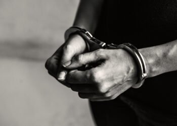 Joven detenido con esposas en sus muñecas (RawPixel/Magnific).
