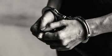 Joven detenido con esposas en sus muñecas (RawPixel/Magnific).