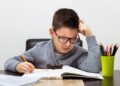 Niño estudiante haciendo la tarea de la escuela (Photoroyalty/Magnific).